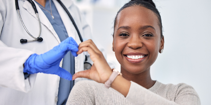 Doctor y paciente haciendo un gesto de corazon con las manos